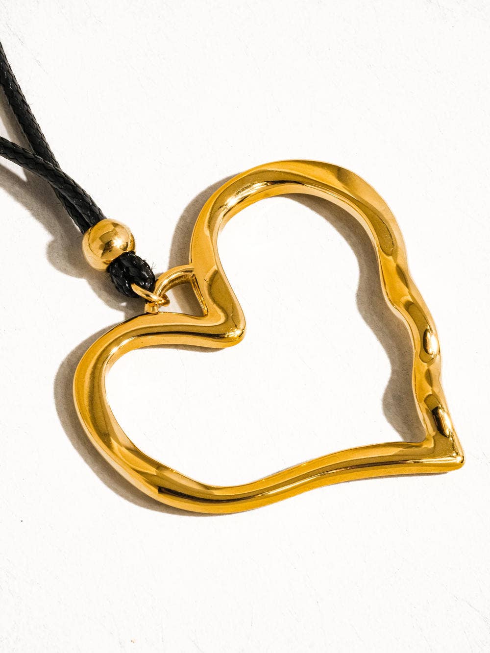 Gold heart-shaped pendant on a white background